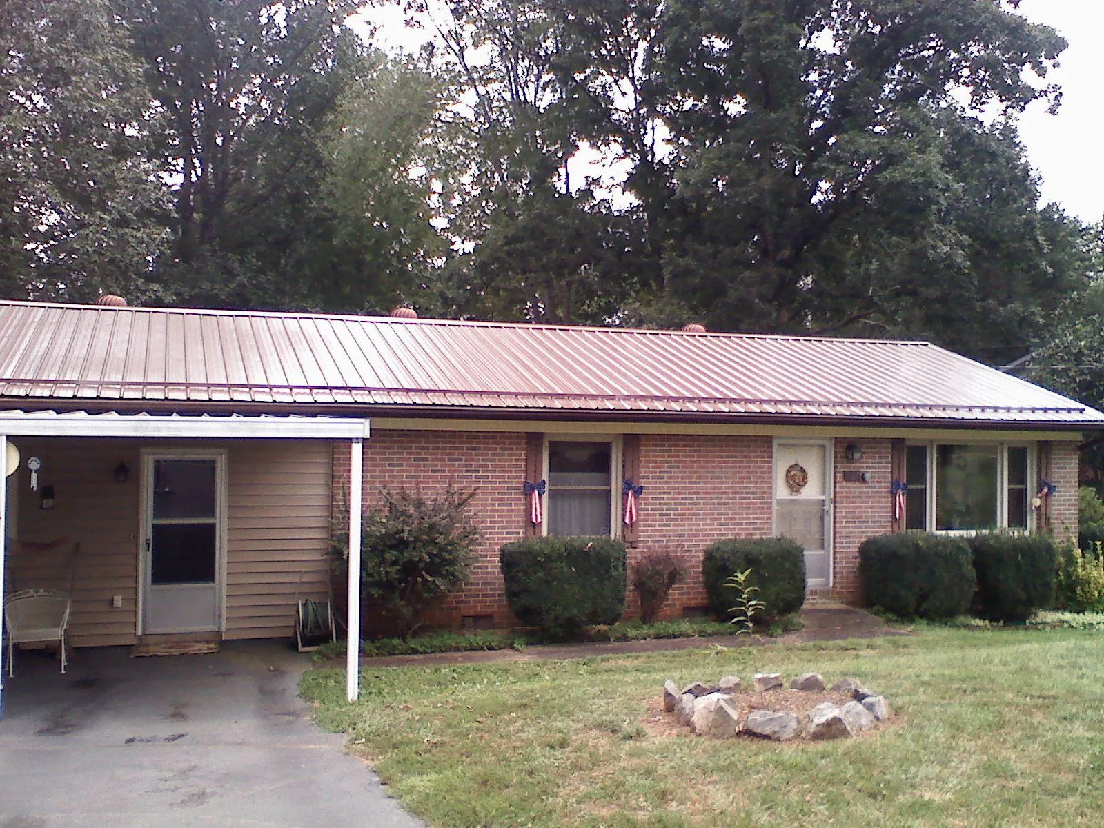 Bronze metal roof and carport on a brick ranch home — Roof Repair work by our crew in Wimberley